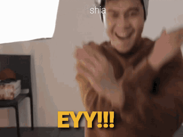 a man is clapping his hands in front of the word eyy !!!