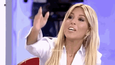 a woman with blonde hair and a white shirt is making a funny face