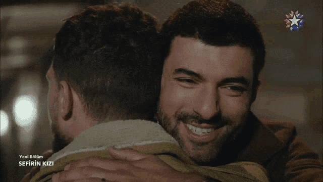 a man hugging another man with the words sefirin kizi on the bottom right
