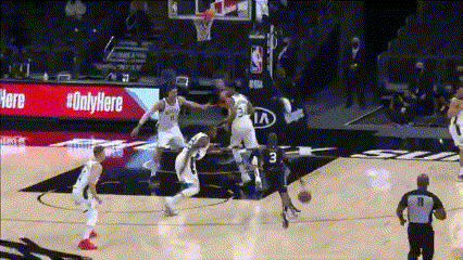 a basketball game is being played in front of a kia sign