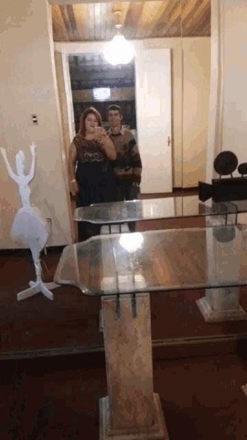 a couple taking a picture of themselves in a mirror