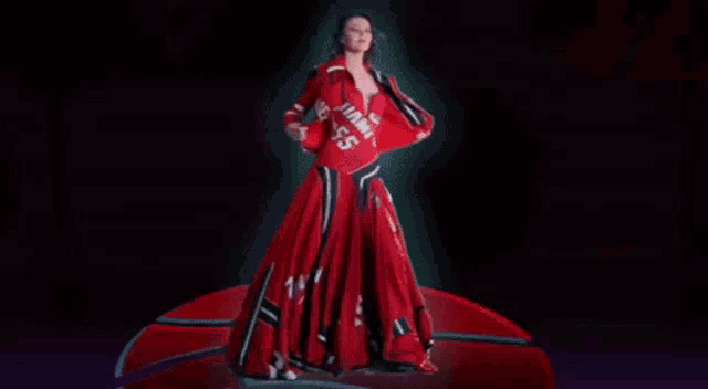 a woman in a red dress is standing on a basketball