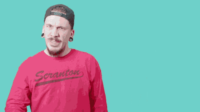 a man wearing a red shirt that says finish him is pointing