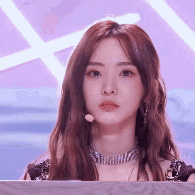 a woman wearing a choker and earrings is looking at the camera