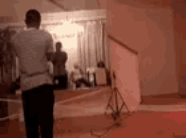 a man is standing in a room taking a picture of a woman .
