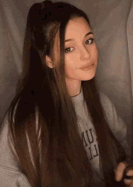 a girl with long hair is wearing a sweater that says uc