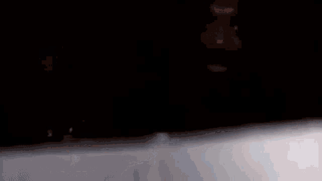 a man 's face is visible in a dark room .