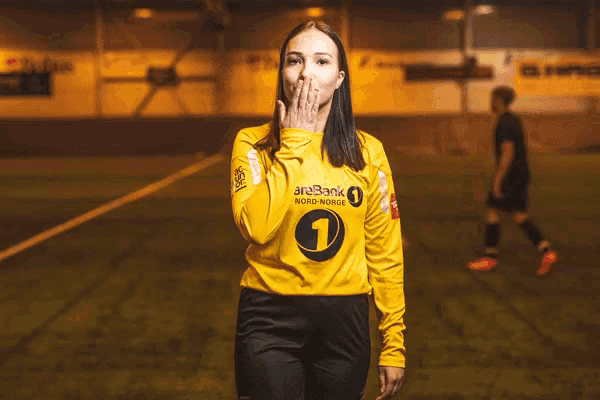 a woman wearing a yellow shirt that says nord norge