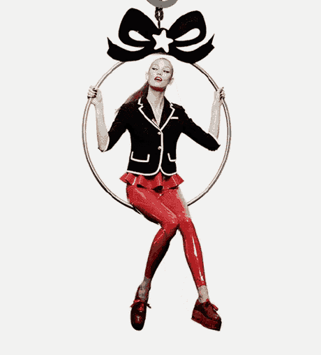a woman is sitting on a hoop with a black bow