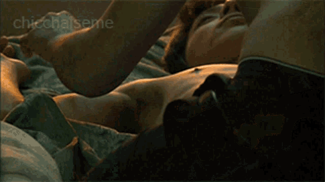 a picture of a man laying on a bed with the words chicchaiseme on the bottom right