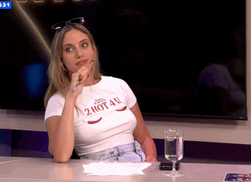 a woman wearing a 2 hot 4u shirt sits at a table