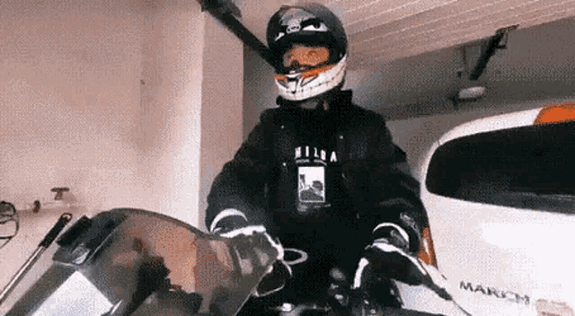 a man is riding a motorcycle in a garage .