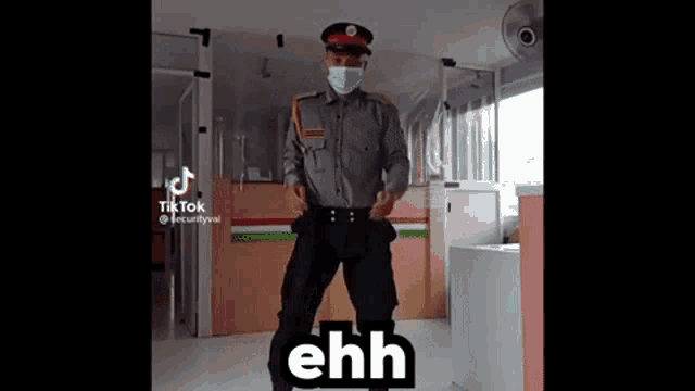 a security guard wearing a mask and hat is dancing in an office .