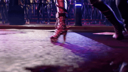 a person wearing a pair of red boots with spikes