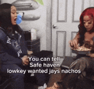 two women are sitting on a couch eating nachos and one of them says you can tell safe haven lowkey wanted jays