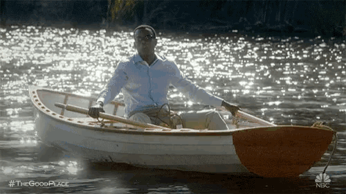 a man is rowing a boat on a lake with a paddle .