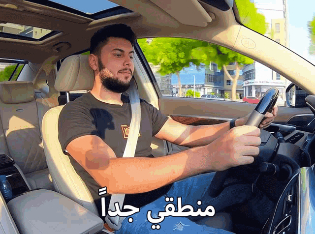 a man sitting in a car with arabic writing on the side