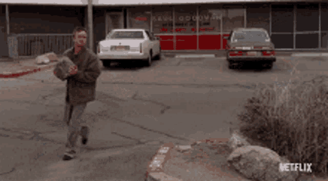 a man holding a large rock in front of a netflix sign