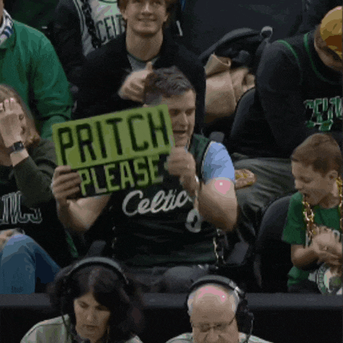 a man in a celtics jersey holds a sign that says pritch please