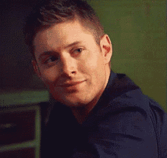 a man is smiling and looking at the camera while wearing a blue shirt .