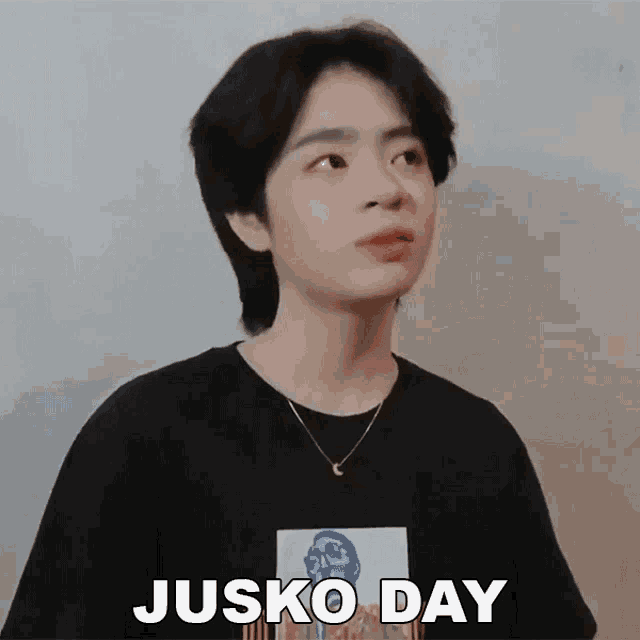 a young man wearing a black shirt and a necklace says jusko day