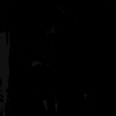 a man in a suit and tie with glasses is standing in a dark room .