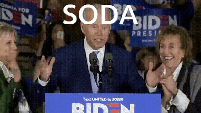 a man in a suit and tie stands at a podium with a sign that says " test united to 30330 "