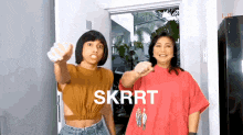 two women are standing next to each other and one of them is pointing at the camera with the word skrrt on the bottom .