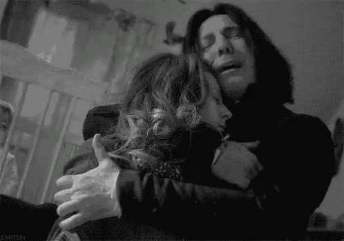 a black and white photo of a man and woman hugging each other .