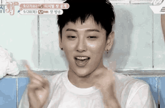 a young man in a white shirt is making a funny face .