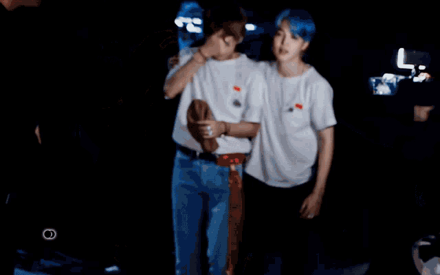 a man with blue hair is standing next to another man with blonde hair