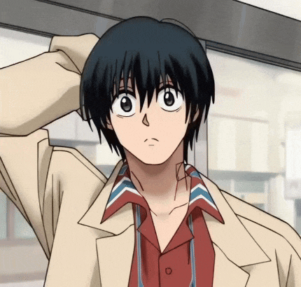 a boy with black hair is wearing a tan jacket and a red and blue shirt
