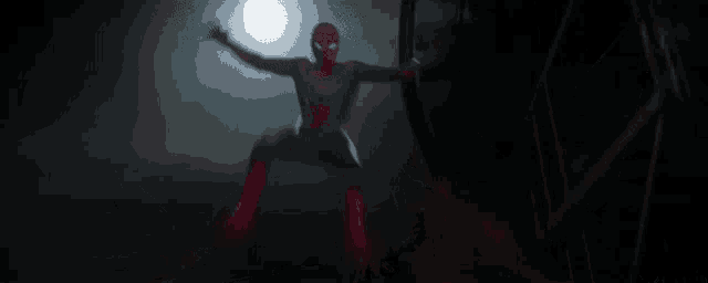 a man in a spiderman costume is flying through the air in the dark .