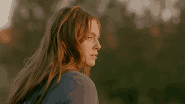 a woman with red hair is looking at the camera
