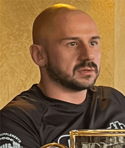 a bald man with a beard is wearing a black shirt that says supplements