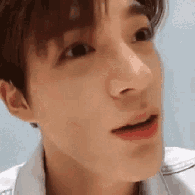 a close up of a young man 's face with his mouth open and a surprised look on his face .