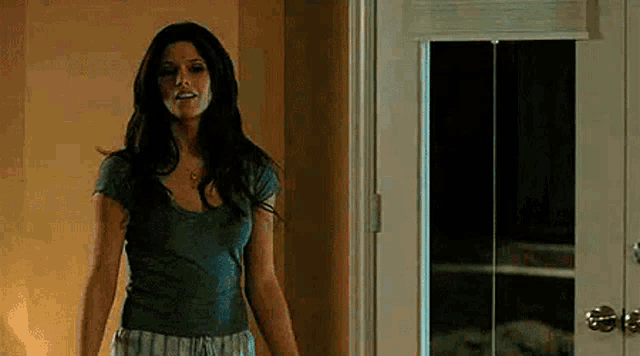 a woman standing in front of a door with a mirror