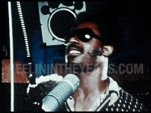a picture of a man singing into a microphone with the website feelintheeye.us.com in the corner