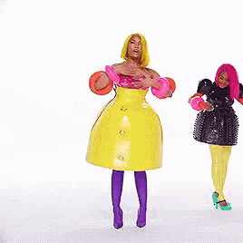 a woman in a yellow dress is standing next to a woman in a pink dress .