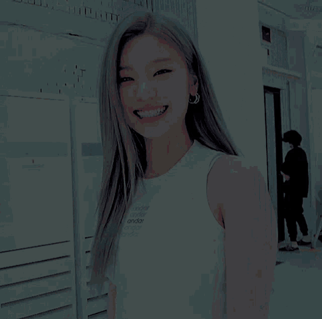 a woman wearing a white tank top with the word andar on it smiles