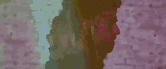 a man with a beard is standing in front of a brick wall with a double exposure of his face .