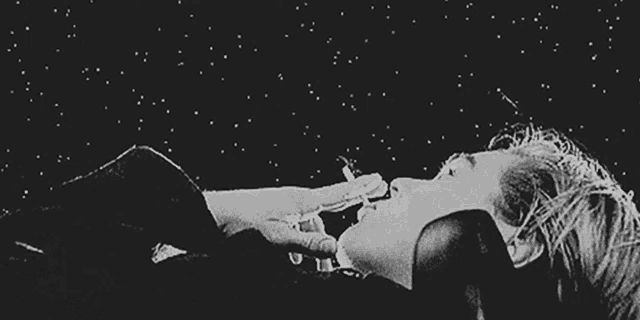 a person is laying down with smoke coming out of their mouth .