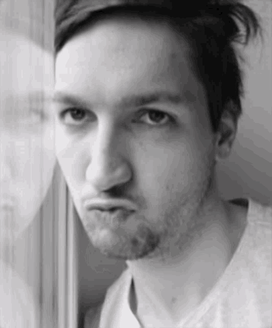 a man with a beard is making a funny face in a black and white photo