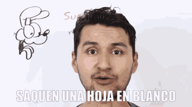 a man in front of a white board with the words saquen una hoja en blanco written on it