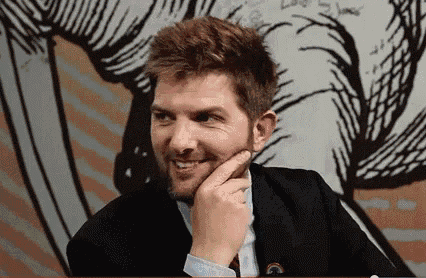 a man in a suit and tie is smiling with his hand on his chin