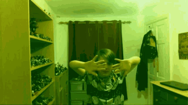 a person covering their face with their hands in front of a window