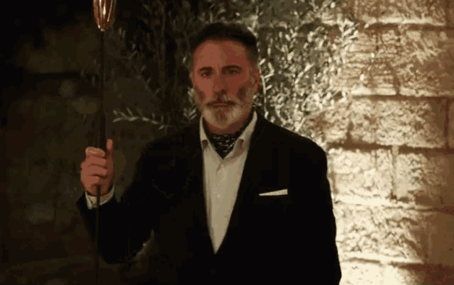 a man in a suit and tie is holding a wine glass