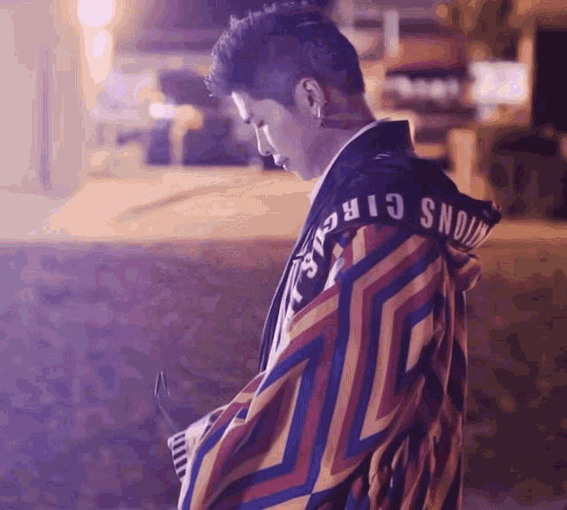 a man wearing a colorful jacket with the word circus on the hood