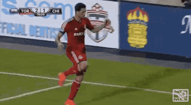 a soccer player in a red jersey with bmo on it