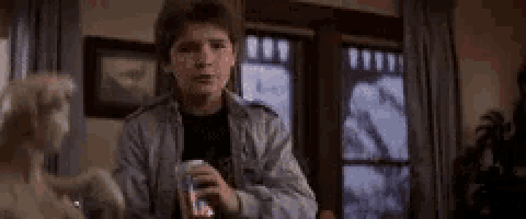 a boy is holding a can of soda in a living room .